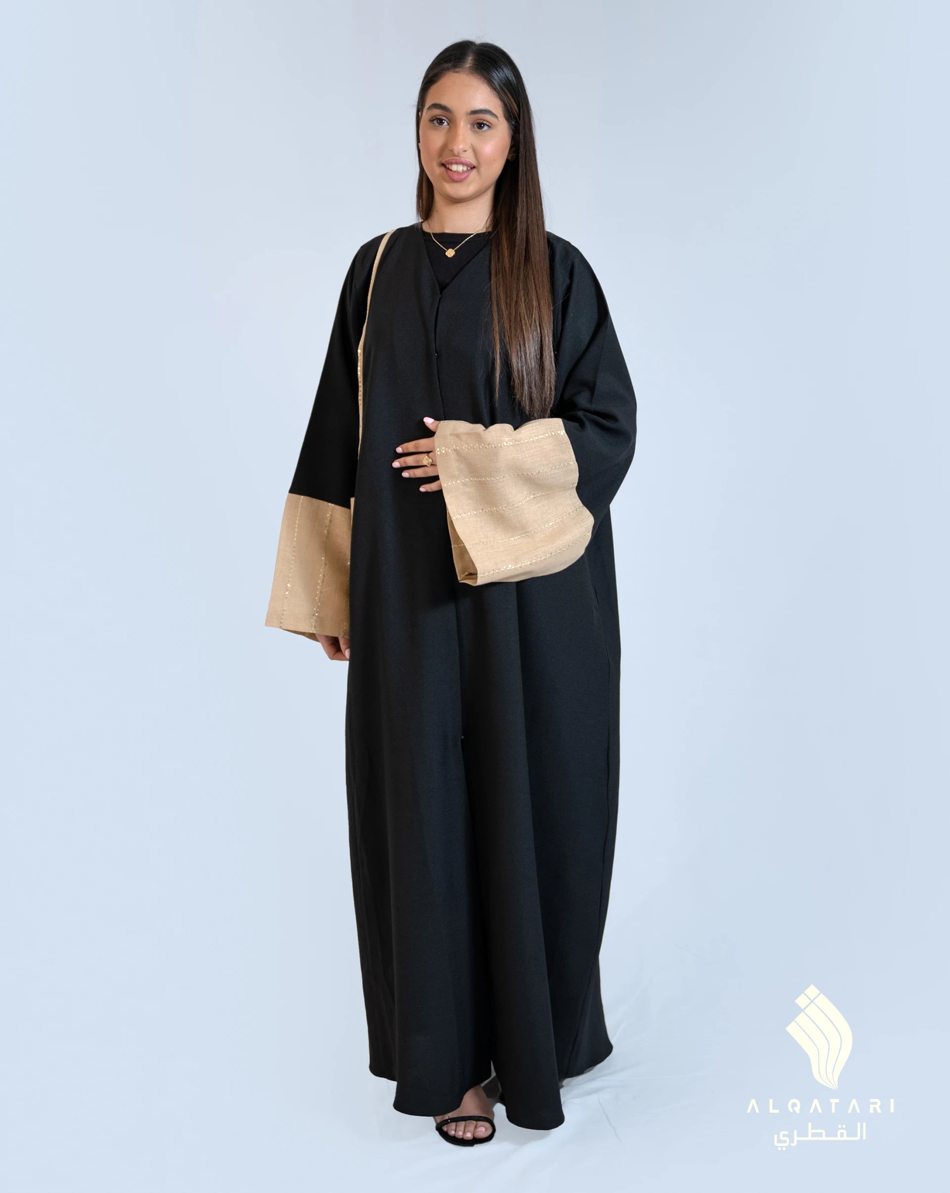Model wearing a black abaya with beige linen sleeves and matching pocket, designed for everyday elegance. Modest fashion by AlQatari Gallery