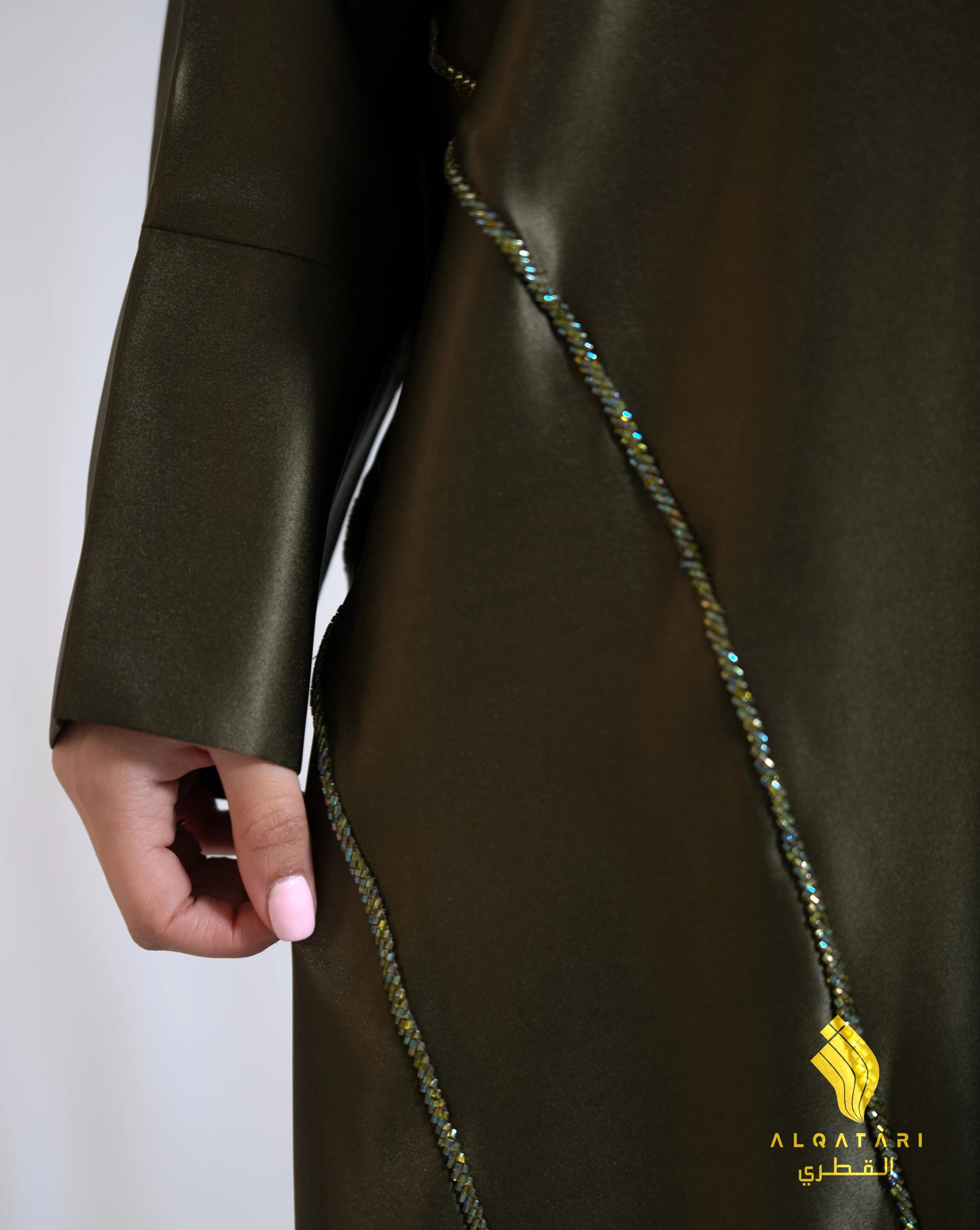 Model wearing a khaki green satin abaya with handwork from the Al Qatari Gallery collection – elegant evening modest wear in size 56.