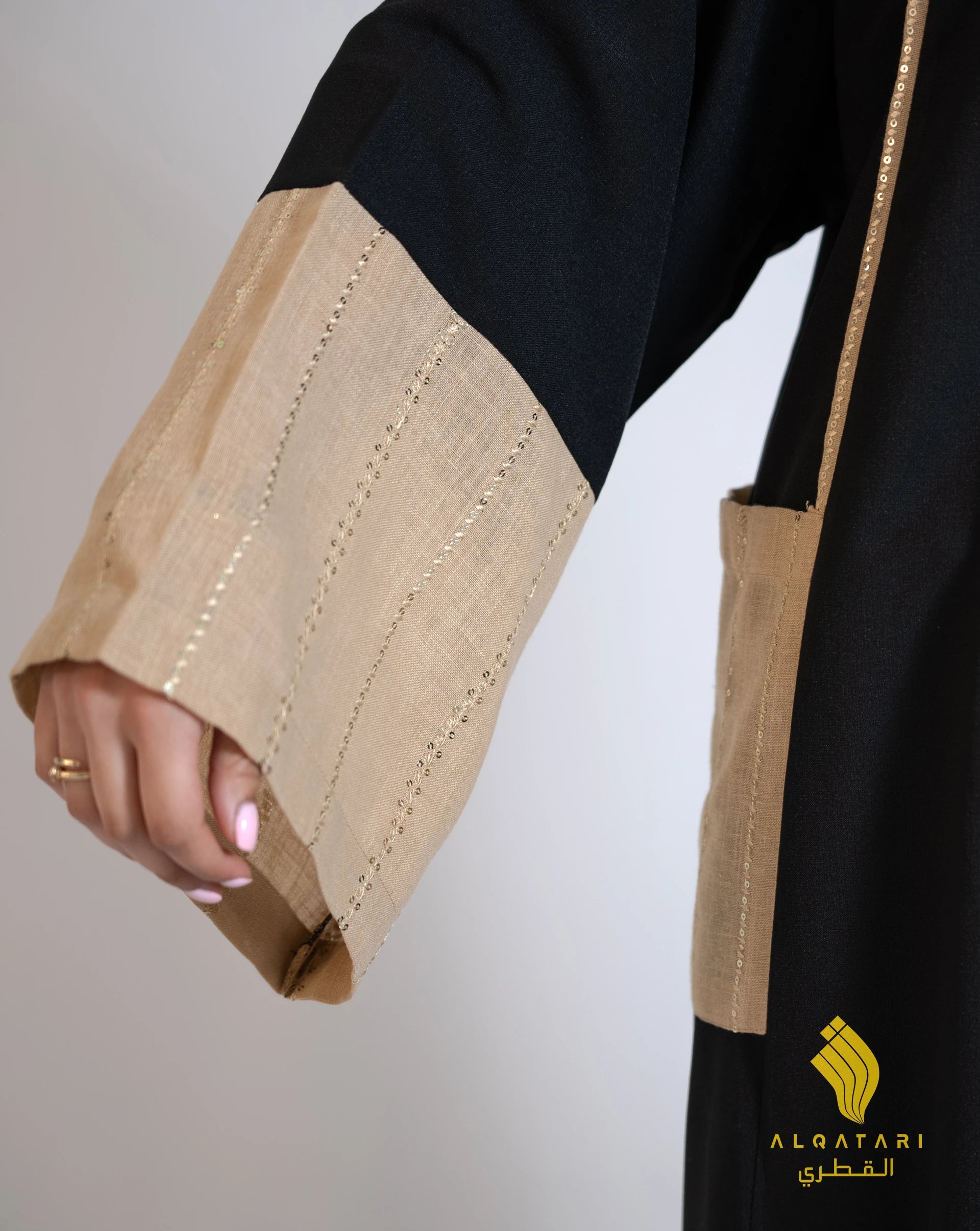 Zoom-in on beige linen sleeve and pocket of the abaya, revealing subtle gold-toned embroidery and clean tailoring. Al Qatari Luxury Abaya