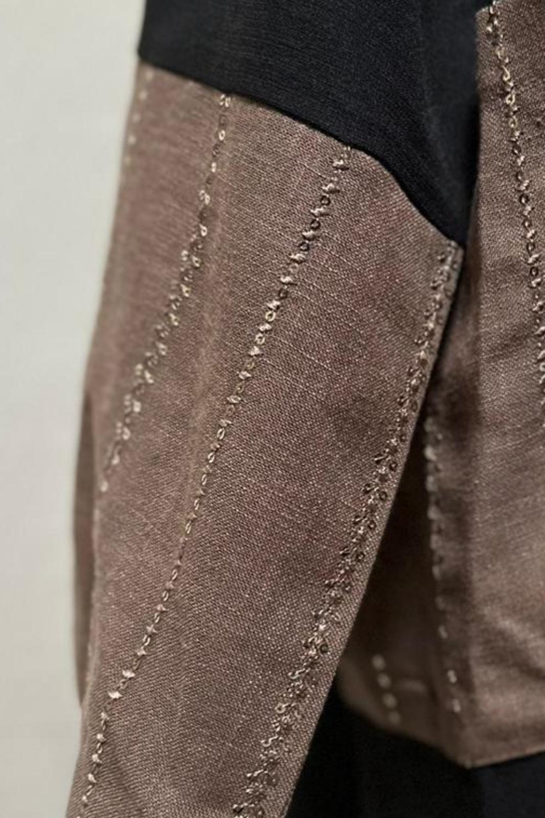 Close-up of the brown linen sleeve with detailed vertical embroidery, showing texture and craftsmanship of the casual Luminance abaya by Al Qatari Gallery