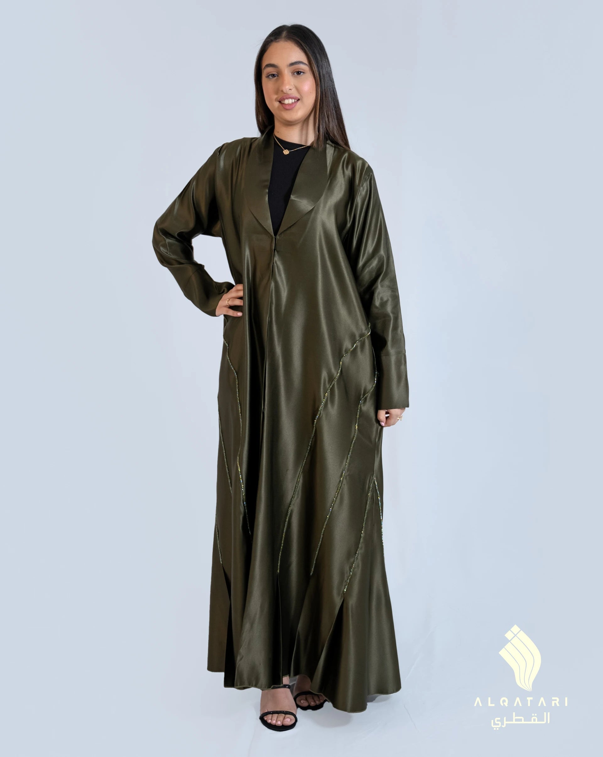 Model wearing a khaki green satin abaya with handwork from the Al Qatari Gallery collection – elegant evening modest wear in size 56.