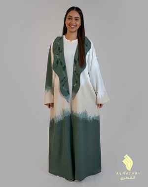Woman wearing a green and white ombré abaya with an embellished wavy collar, designed to mimic ocean waves. Part of a 3-piece summer abaya set by Al Qatari Gallery collection