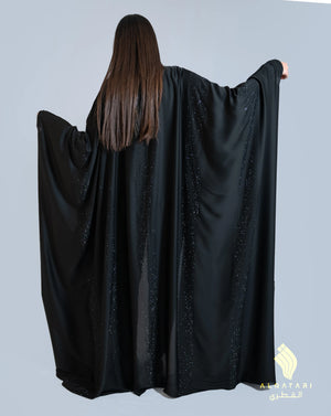 Back view of the Bahraini abaya from Al Qatari Gallery, revealing flowing satin panels adorned with linear beaded embellishments that shimmer with movement.