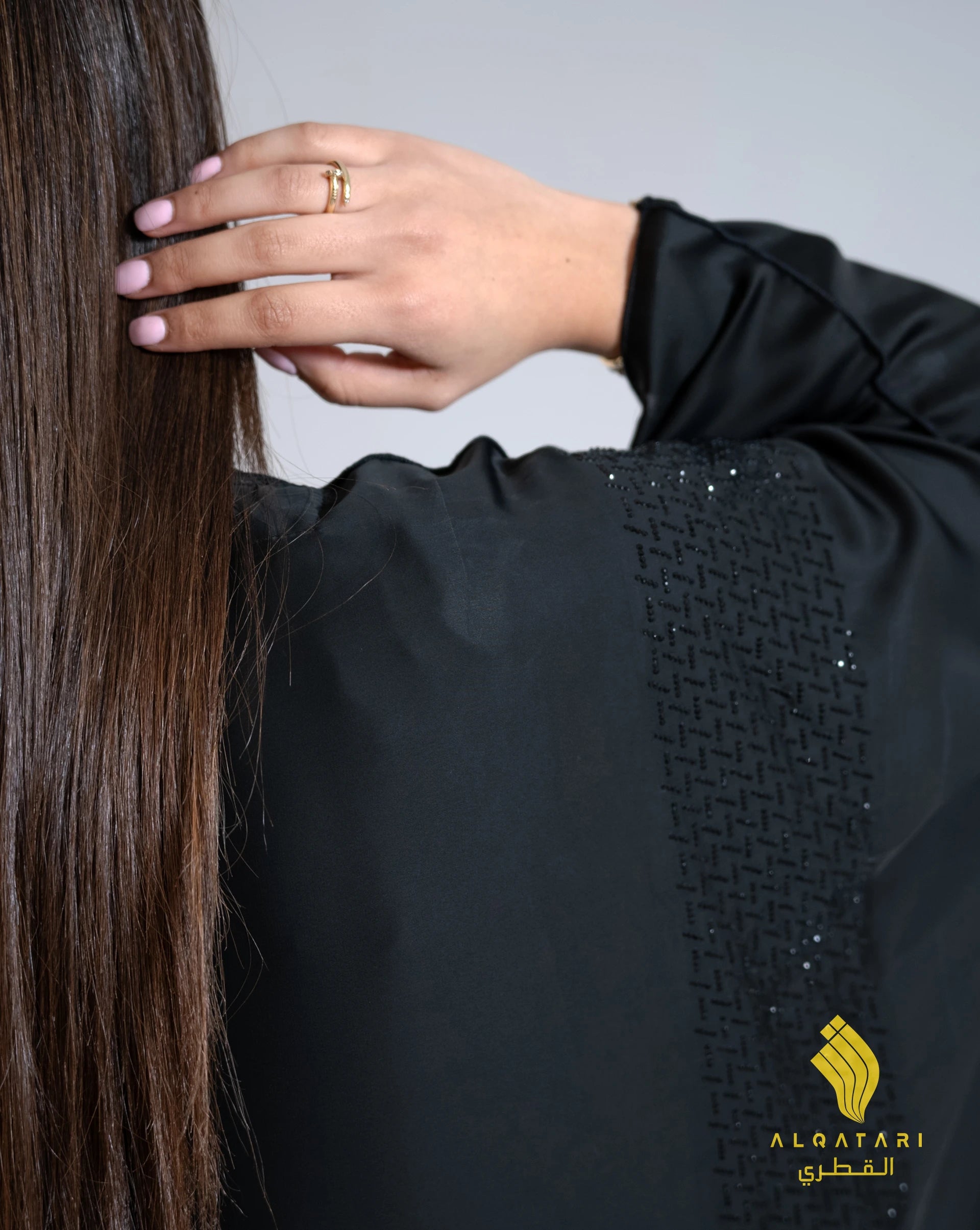 Close-up of shoulder beadwork on the luxury abaya from Al Qatari Gallery, featuring hand-applied black beads in geometric patterns on luxurious pure satin fabric.