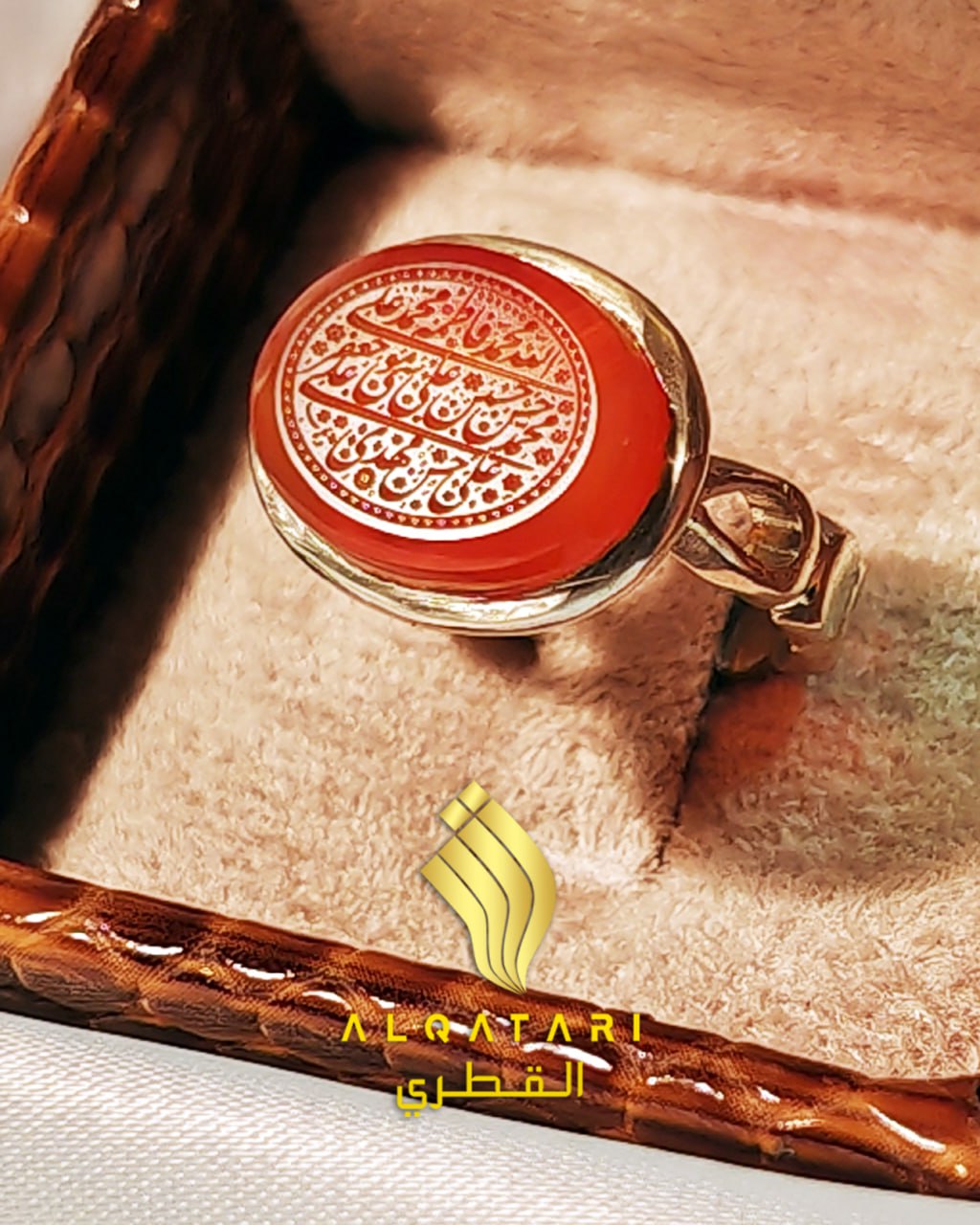 Top view of engraved red agate gemstone ring with Arabic inscription og Allah, the Ahlul Bayt and the 12 Imams in a velvet box