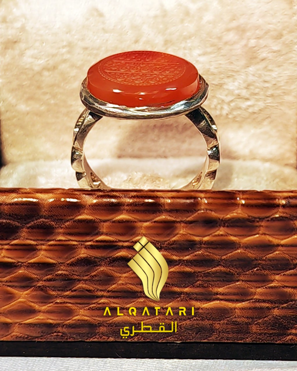 Red agate engraved ring with detailed silver band shown from side angle in gift box