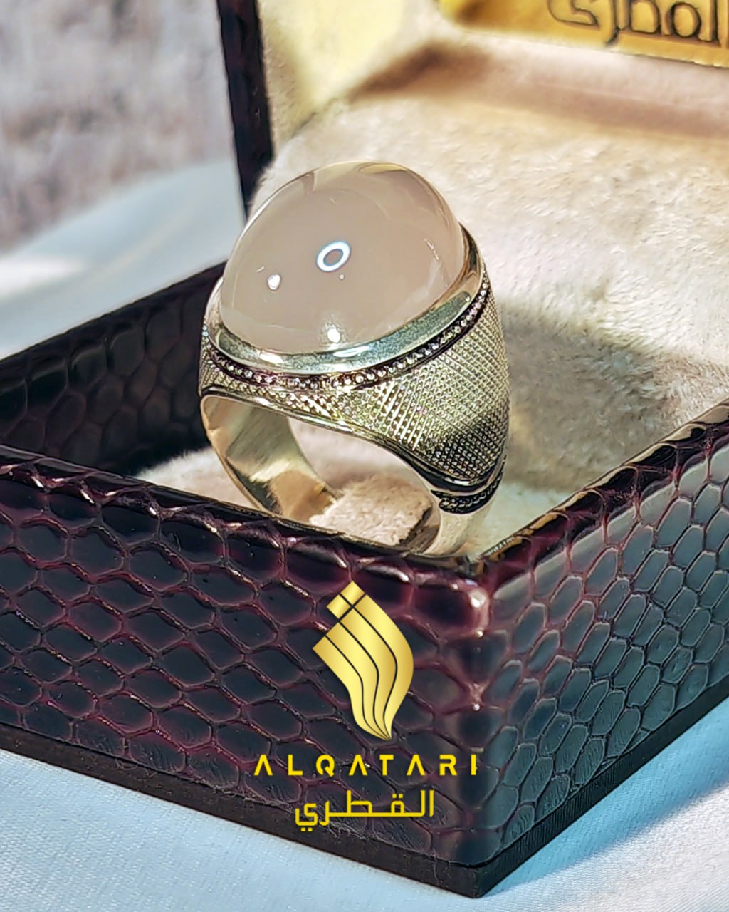 Peach gemstone ring with detailed silver basket weave shank and wide bezel in Al Qatari box
