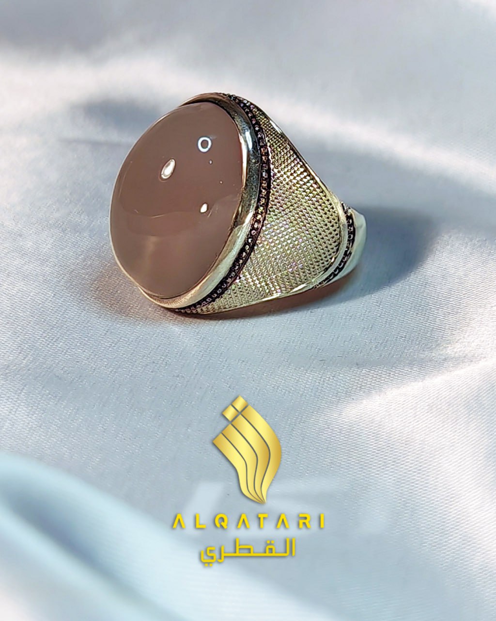 Side view of peach domed chalcedony men’s ring on satin background by Al Qatari