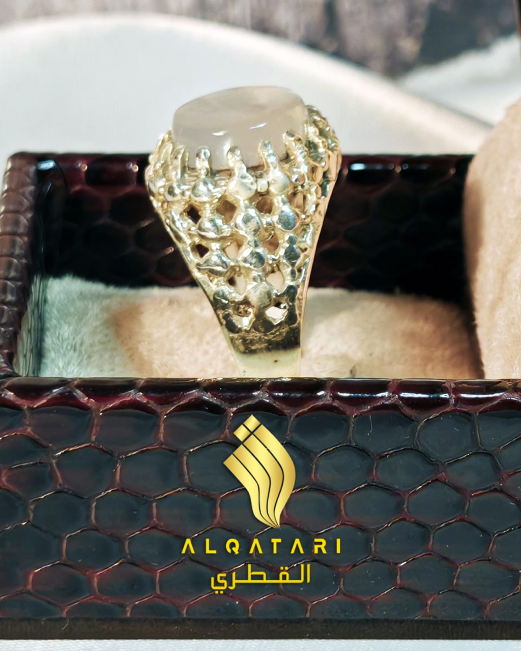 Frontal view of moonstone-style dur e najaf islamic gemstone ring in open gold mesh setting, presented in gift box