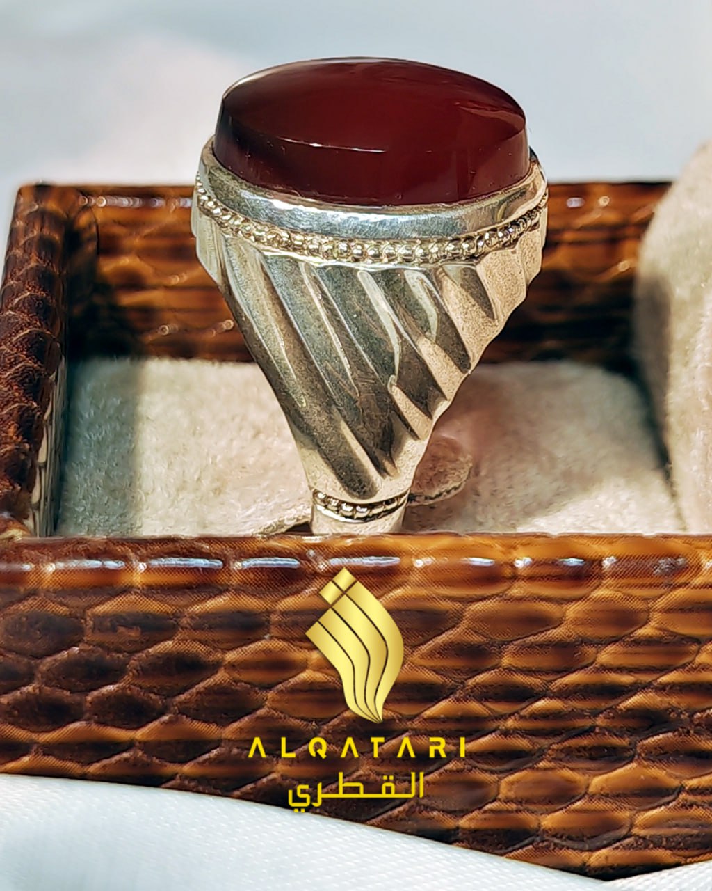 Detailed side view of the Alqatari men’s silver Aqeeq ring inside a brown luxury ring box