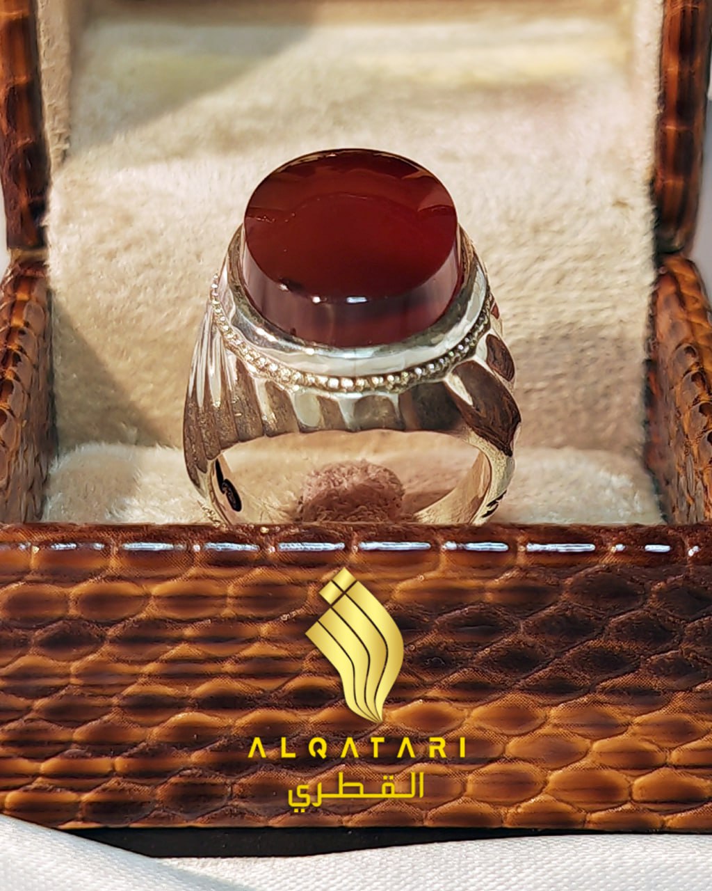 Top view of AlQatari’s handcrafted silver ring featuring a deep red Aqeeq gemstone in a padded display box