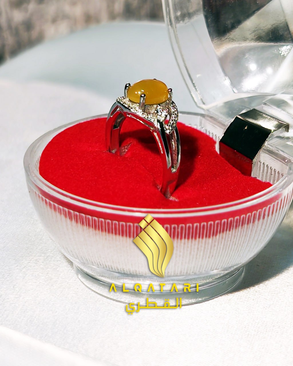 Side view of Al Qatari yellow Aqeeq ring in a transparent gift box with red velvet base