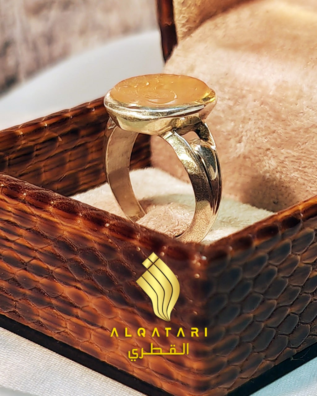 Side profile of handcrafted amber calligraphy ring showing silver band and setting