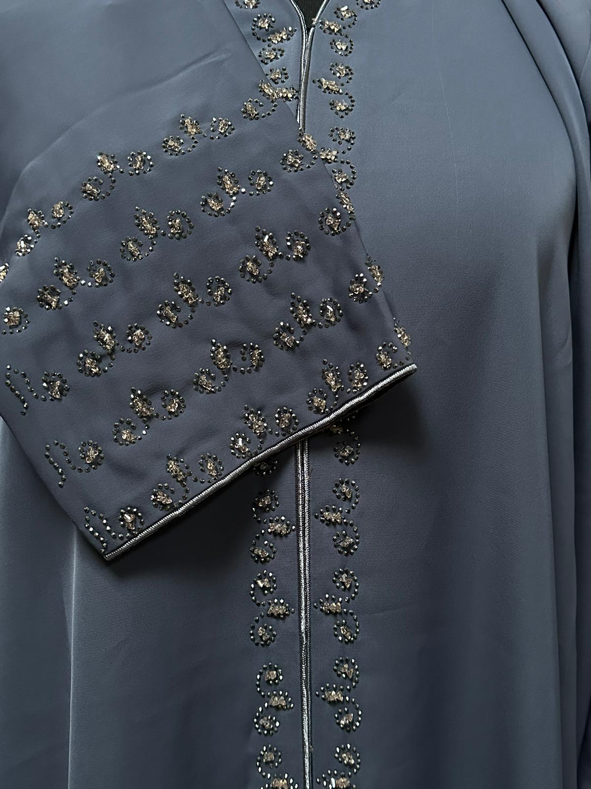 Grey version of the Mirage abaya, laid flat to show contrast bead embroidery on the sleeve and front panel for a luxurious finish. AlQatariGallery