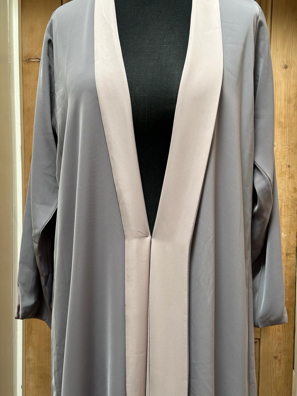 Beige and light grey version of the reversible abaya displayed on mannequin, showing the smooth drape of Nada fabric.