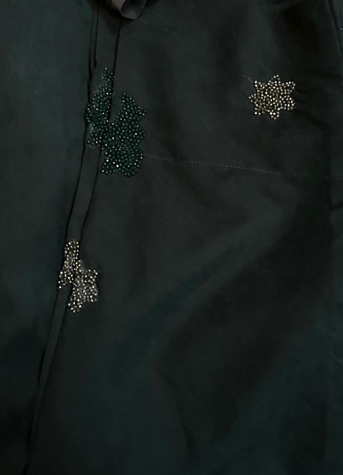 Zoom-in of bottle green version of the abaya from Al Qatari Gallery with variously toned beadwork, showcasing deep texture and elegance.