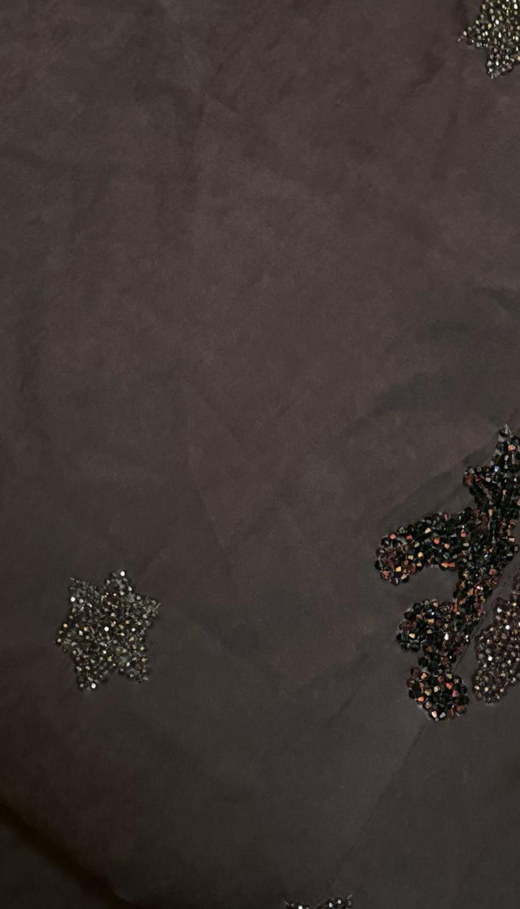Detail of mauve suede abaya from Al Qatari Gallery with clustered bead embellishments forming abstract floral and star patterns.